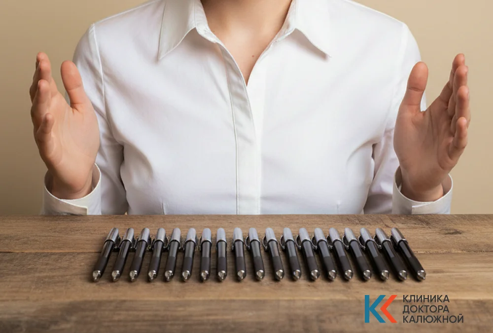 Девушка разложила ручки в ряд на столе